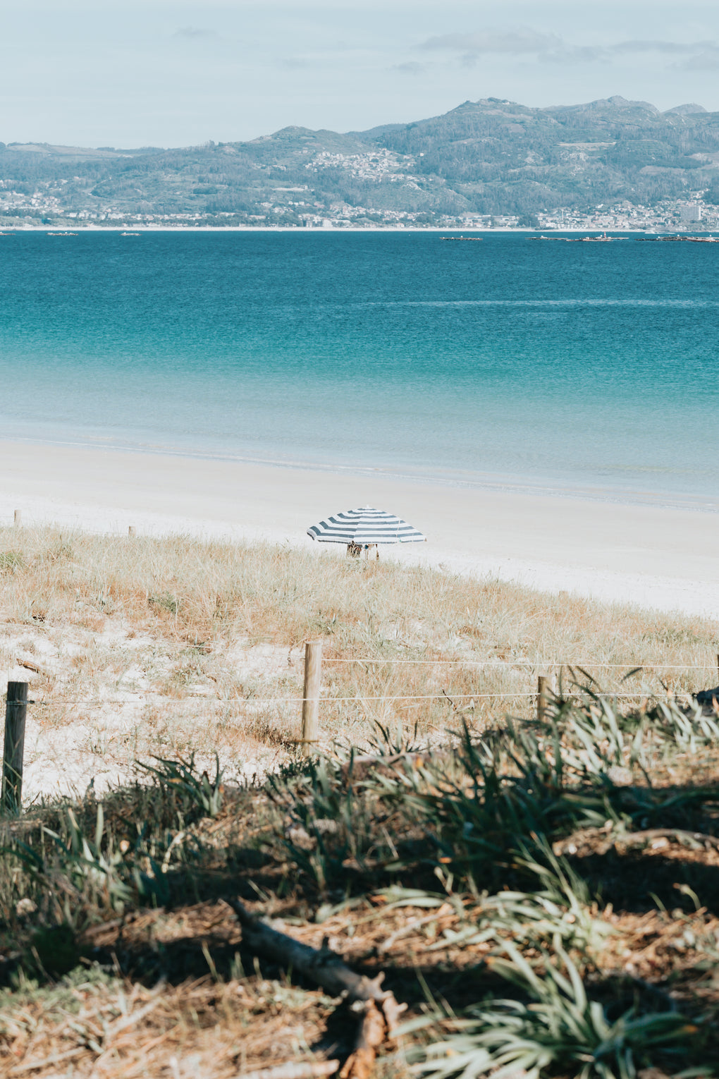 beach-with-aqua-blue-water-and-a-single-beach-umbrella